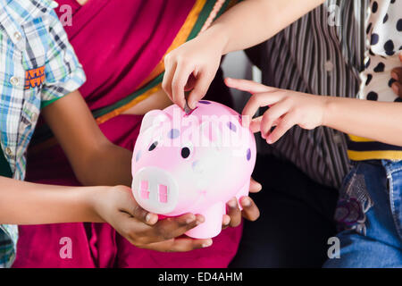 Les parents ayant des enfants d'économiser de l'argent Tirelire Banque D'Images