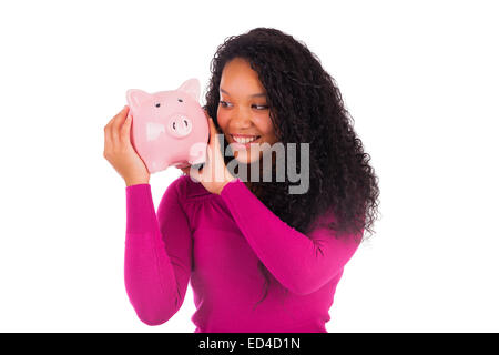 Young african american woman putting coins in piggy bank isolated Banque D'Images