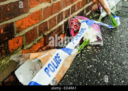 Belfast, Irlande du Nord. 27 déc 2014 - bande de la police se trouve sur l'extérieur de fleurs une maison où un meurtre a eu lieu Crédit : Stephen Barnes/Alamy Live News Banque D'Images