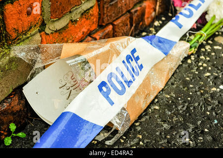 Belfast, Irlande du Nord. 27 déc 2014 - bande de la police se trouve sur l'extérieur de fleurs une maison où un meurtre a eu lieu Crédit : Stephen Barnes/Alamy Live News Banque D'Images