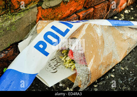 Belfast, Irlande du Nord. 27 déc 2014 - bande de la police se trouve sur l'extérieur de fleurs une maison où un meurtre a eu lieu Crédit : Stephen Barnes/Alamy Live News Banque D'Images