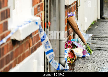 Belfast, Irlande du Nord. 27 déc 2014 - bande de la police se trouve sur l'extérieur de fleurs une maison où un meurtre a eu lieu. Crédit : Stephen Barnes/Alamy Live News Banque D'Images