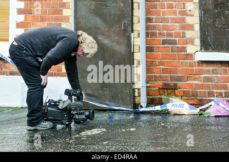 Belfast, Irlande du Nord. 27 déc 2014 - Un caméraman de la BBC, Albert Kirk, films à l'extérieur de la maison des fleurs d'une victime de meurtre Crédit : Stephen Barnes/Alamy Live News Banque D'Images