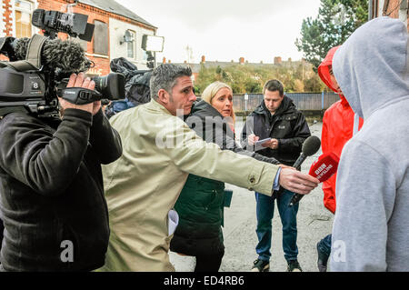 Belfast, Irlande du Nord. 27 déc 2014 - reporters de télévision et les journalistes noter la réaction de deux jeunes hommes à la suite d'un meurtre. Crédit : Stephen Barnes/Alamy Live News Banque D'Images