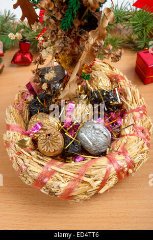 Décoration de Noël merveilleux avec panier en osier avec de la paille et les écrous à l'intérieur en bois de couleur brun clair sur la surface. Christian fe Banque D'Images