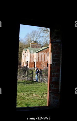 La plaine de Salisbury, Wiltshire, UK, le 27 décembre 2014. Un couple marche à l'extérieur des chalets abandonnés il y a 70 ans, évacué par l'armée en 1943 en préparation d'DDay et reste aujourd'hui déserte. Comme un geste de bonne volonté du Ministère de la défense permet aux visiteurs de la commune les jours fériés. Credit : Wayne Farrell/Alamy Live News Banque D'Images