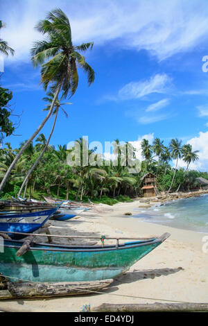 Les bateaux de pêche traditionnels du Sri Lanka et maison sur pilotis en bois restaurant sur une plage de sable, à Tangalle, au Sri Lanka, en Asie. Banque D'Images