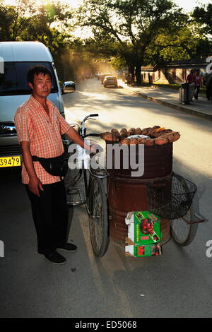 Vendeur de rue man selling roasted sweet potato qui est une rue populaire snack en Chine. Près de l'Impérial Palace Beijing d'été Banque D'Images