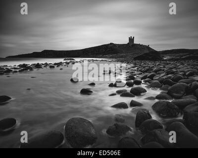 Une vue sur Château De Dunstanburgh de Embleton Bay. Une exposition d'une minute converti en monochrome. Banque D'Images