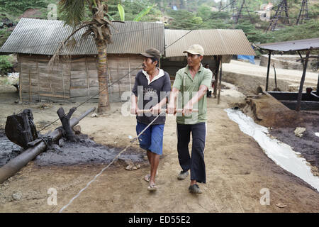 Tirez les mineurs de la mine au lever du pétrole brut à partir du puits manuellement dans l'exploitation minière pétrole traditionnel dans Kedewan Bojonegor sous-district, Banque D'Images