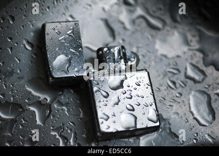 Briquet Zippo dans la pluie, La vie toujours plus léger et avec des gouttes d'eau Banque D'Images