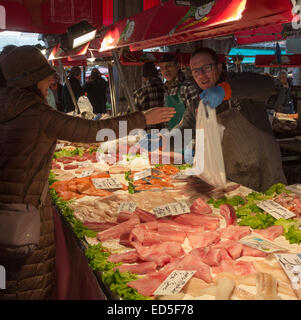 Le client paie pour les poissons, pescheria ou le marché aux poissons, le Rialto, Venise, Italie Banque D'Images