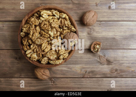 Les noix dans le bol en bois table en bois Banque D'Images