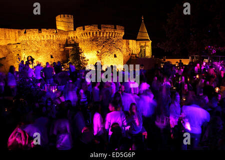 Les gens danser à la Terrassa night club à Belgrade, en Serbie. Le Zindan porte de la forteresse de Kalmegdan est illuminée en t Banque D'Images