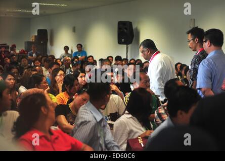Jakarta, Indonésie. Dec 29, 2014. AirAsia Group chief executive officer Tony Fernandes (C) passe devant les membres de la famille des personnes disparues sur vol AirAsia QZ8501 à l'aéroport international de Juanda à Surabaya, Indonésie, le 29 décembre 2014. Le Vice-Président indonésien Jusuf Kalla a déclaré lundi que les chercheurs et les sauveteurs ont été vérifier tout objet suspect repéré dans la mer de Java où un avion AirAsia a disparu le dimanche. Credit : Zulkarnain/Xinhua/Alamy Live News Banque D'Images