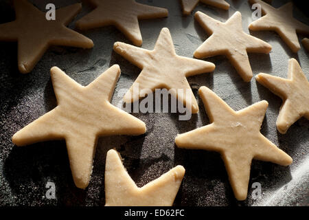 Pâte crue biscuits de Noël en forme d'étoiles sur une plaque de cuisson prêt à aller dans le four de Galles UK KATHY DEWITT Banque D'Images