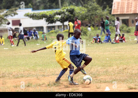 Wakiso, en Ouganda. 29 Décembre, 2014. Les enfants ougandais, représenté à un match de football sur terrain poussiéreux durant la fin de l'année 2015 fêtes de fin d'année. Le développement fait face à un grand football défi en raison de mauvaises installations dans le continent africain. Credit : Samson Opus/Alamy Live News Banque D'Images