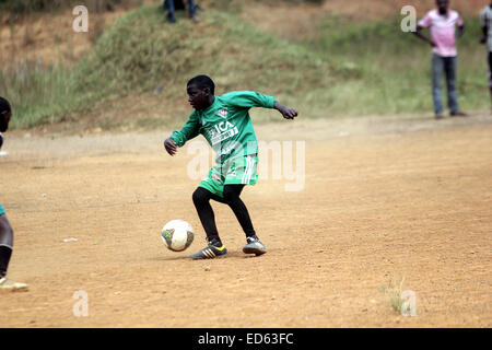 Wakiso, en Ouganda. 29 Décembre, 2014. Les jeunes Ougandais prendre le temps de jouer au football sur terrain poussiéreux durant la fin de l'année 2015 fêtes de fin d'année. Le développement fait face à un grand football défi en raison de mauvaises installations dans le continent africain. Credit : Samson Opus/Alamy Live News Banque D'Images