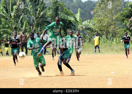 Wakiso, en Ouganda. 29 Décembre, 2014. Les jeunes Ougandais prendre le temps de jouer au soccer sur bmpy terrain poussiéreux durant la fin de l'année 2015 fêtes de fin d'année. Le développement fait face à un grand football défi en raison de mauvaises installations dans le continent africain. Credit : Samson Opus/Alamy Live News Banque D'Images