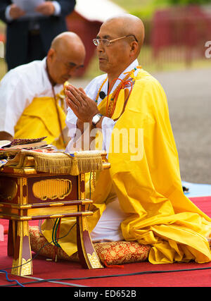 Un abbé de l'ordre Nipponzan Myohoji en prière au cours de la cérémonie de commémoration annuelle au Battersea Park de la Pagode de la paix. Banque D'Images