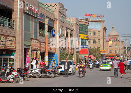 Scooters en rue commerçante animée dans la ville Kashgar / Kashi, la Province du Xinjiang, Chine Banque D'Images