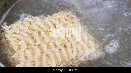 Un paquet de nouilles ramen instantané est préparé à l'eau bouillante sur une cuisinière à New York le Mardi, Décembre 23, 2014. Une récente étude publiée dans le Journal of Nutrition a déclaré que certaines personnes sont plus à risque de syndrome métabolique, qui comprend les accidents vasculaires cérébraux, les maladies cardiaques et le diabète, après avoir consommé deux ou plusieurs paquets de ramen une semaine sur une période de temps. (© Richard B. Levine) Banque D'Images