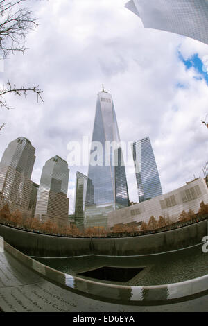 One World Trade Center se lève sur les visiteurs du Mémorial National du 11 septembre & Museum de New York à Noël, le Jeudi, Décembre 25, 2014. Le monument commémoratif est composé de deux piscines sur les traces du World Trade Center et d'une place plantée de plus de 400 arbres chêne bicolore. Les noms des 2983 victimes des attentats du 11 septembre et février 1993 le WTC sont inscrits autour de la base de l'eau. (© Richard B. Levine) Banque D'Images