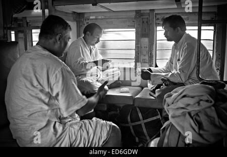 Calcutta, le Bengale occidental, en Inde. 14 avr, 2011. Dans une deuxième classe sleeper train voiture qui fait le voyage de Bombay à Calcutta (le trajet dure entre deux et trois jours de voyage) un groupe de l'homme passe le temps à jouer aux cartes. (Mars 2011) -- Kolkata (Calcutta) est un tournant dans le sous-continent indien. Ville d'un glorieux passé colonial (ancienne capitale de l'Inde britannique jusqu'au début du xxe siècle) voit maintenant comment d'autres villes du pays, comme Bombay ou New Delhi, la croissance de l'économie du pays. Entre-temps, le bengali ville reste liée à la stigmatisation de la pauvreté et du sous-développement s Banque D'Images