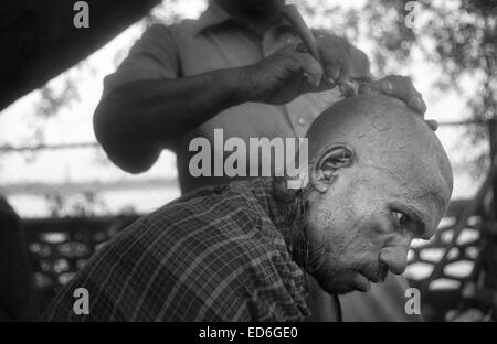 Calcutta, le Bengale occidental, en Inde. 14 avr, 2011. Un homme se rase la tête à un autre homme sur les rives du fleuve Hooghly à Calcutta. La tête de rasage est partie de le rituel de deuil pour religiÃ³n hindouiste. (Mars 2011) -- Kolkata (Calcutta) est un tournant dans le sous-continent indien. Ville d'un glorieux passé colonial (ancienne capitale de l'Inde britannique jusqu'au début du xxe siècle) voit maintenant comment d'autres villes du pays, comme Bombay ou New Delhi, la croissance de l'économie du pays. Entre-temps, le bengali ville reste liée à la stigmatisation de la pauvreté et du sous-développement depuis le déclin de l'ECON Banque D'Images