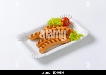 Grillades de saucisses de Vienne sur l'assiette de porcelaine blanche Banque D'Images