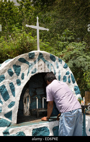 L'Ile Maurice, tamarin, l'homme en allumant des bougies sanctuaire catholique routière Banque D'Images