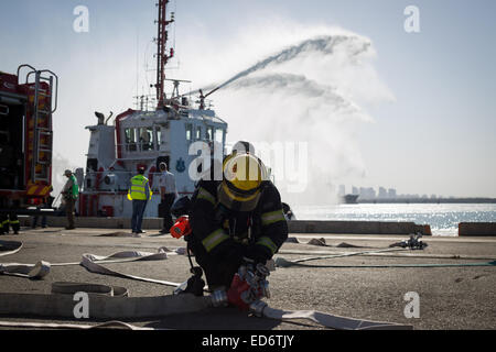 (141230) -- JÉRUSALEM, 30 décembre 2014 (Xinhua) -- Un Israélien fire fighter assiste à un exercice de sauvetage au port d'Ashdod, dans le sud d'Israël, le 29 décembre 2014. L'exercice de sauvetage, régulièrement pratiqué comme un scénario, était fondée sur une infiltration terroriste avec l'utilisation de matières dangereuses par voie maritime. (Xinhua/JINI/Albert Sadikov) Banque D'Images