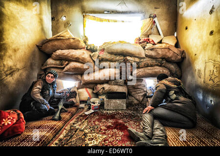 Kobane, la Syrie. Dec 21, 2014. Pompiers en Kobane des positions de l'homme à l'appui de l'avancement des troupes au sol dans la bataille pour l'Kobane contre l'Etat islamique. Les forces kurdes sont entièrement l'intégré. Les combattants féminins montrent beaucoup d'humilité et de l'efficacité en tant que membres dans la lutte pour la survie de leur pays. © Gail Orenstein/ZUMA/Alamy Fil Live News Banque D'Images