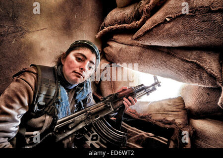 Kobane, la Syrie. Dec 21, 2014. Pompiers en Kobane des positions de l'homme à l'appui de l'avancement des troupes au sol dans la bataille pour l'Kobane contre l'Etat islamique. Les forces kurdes sont entièrement l'intégré. Les combattants féminins montrent beaucoup d'humilité et de l'efficacité en tant que membres dans la lutte pour la survie de leur pays. © Gail Orenstein/ZUMA/Alamy Fil Live News Banque D'Images