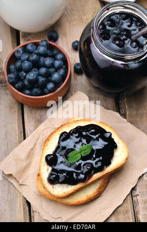 Confiture sur des toasts de pain sur table en bois Banque D'Images