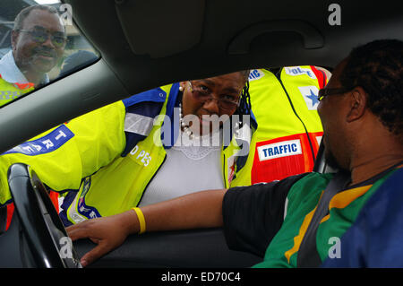 Durban, Afrique du Sud. 30 Décembre, 2014. Le ministre des Transports de l'Afrique du Sud Dipuo Peters parle d'un automobiliste à un barrage routier à Durban peu après il a été annoncé que dans les 28 premiers jours de décembre 1143 personnes ont été tuées sur les routes du pays. En haut à gauche, à travers le pare-brise, le KwaZulu-Natal Willies Mchunu MEC provinciaux des transports peut être vu à la recherche sur. Plus de 15 000 personnes meurent sur les routes du pays chaque année. Credit : Giordano Stolley/Alamy Live News Banque D'Images