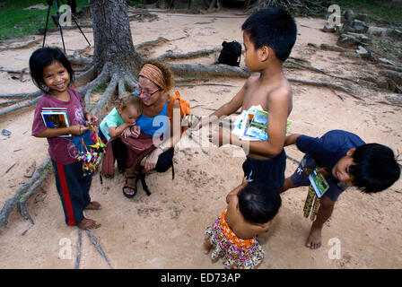 Voyager avec des enfants. Les garçons la vente de cartes postales et souvenirs d'une mère marcher avec sa fille. Ta Som Temple. Le Cambodge. T Banque D'Images