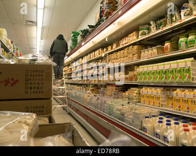 Les stocks de travailleur dans un marché asiatique des étagères à Albany, New York. Banque D'Images