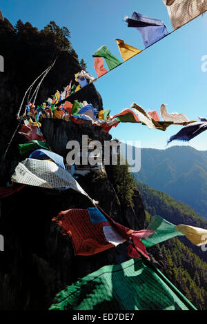 Vue à travers Lung Ta Tibétain Prayer drapeaux de Paro Taktsang également connu sous le nom de Taktsang Palphug Monastère et le Tigren's Nest) un site sacré himalayan et complexe de temple situé dans la falaise de la vallée supérieure de Paro au Bhoutan. Banque D'Images
