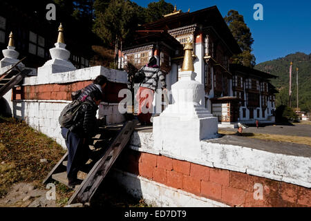 Les bouddhistes fervents entrant dans le monastère bouddhiste de Kurjey Lhakhang qui se compose de trois grands temples entourés d'un périmètre de 108 stupas situé dans la vallée de Bumthang dans le district de Bumthang Bhoutan Banque D'Images