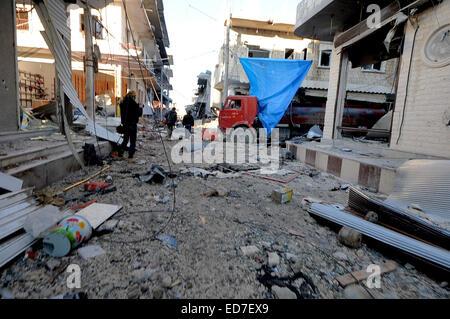 Kobane, la Syrie. Dec 21, 2014. Les défenseurs kurdes des Kobane appeler leur ville ''Stalingrad''. Les rues sont remplis de gravats, éclats de verre recouvre le sol partout, et des morceaux de métal et les éclats couvrir le sol. La plupart des maisons sont réduites à leurs cadres et des bombes non explosées emplissent les rues. Dans cette ville en ruines les survivants doivent faire face à l'aide d'armes légères, des roquettes, des explosifs et des attaques aériennes alliées d'une violence extrême. Pour vous déplacer sur l'un doit passer à travers les trous dans les murs entre les bâtiments frappé ou sous les draps tendus sur des espaces ouverts pour obstruer la vue des tireurs isolés. Dans les décombres petite j Banque D'Images