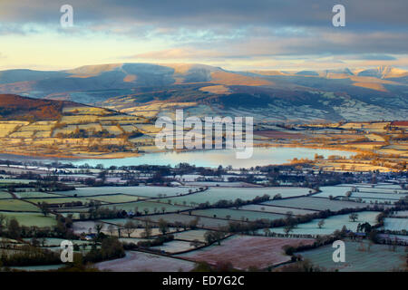 Vue sur le lac de Llangorse et les Brecon Beacons, enneigés de Mynydd Troed, Powys. Banque D'Images
