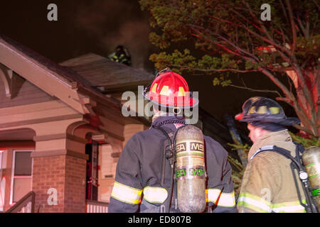 Les équipes de pompiers de Milwaukee Leutenant regarder sur le toit d'une maison avec un feu électrique Banque D'Images