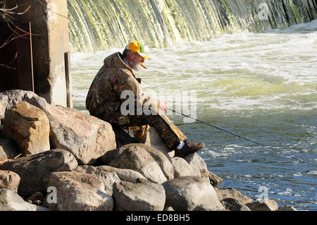 Pêcheur solitaire de pêche près de la rive du barrage de la rivière. Banque D'Images