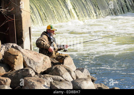 Pêcheur solitaire de pêche près de la rive du barrage de la rivière. Banque D'Images