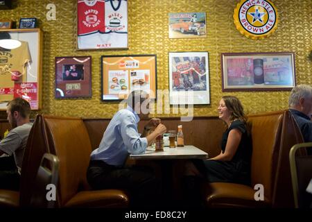 Le président américain Barack Obama partage un rire tout en déjeunant avec Rebecca Erler à Matt's Bar le 26 juin 2014 à Minneapolis, Minnesota. Erler, a 36 ans, épouse et mère de deux garçons en âge pré-scolaire, avait écrit une lettre au Président sur les défis économiques d'élever une famille. Quand un voyage à Minneapolis a été programmé, le Président a invité Rebecca de déjeuner avec lui. Banque D'Images