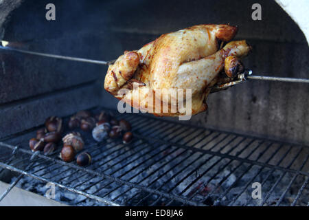 Un poulet rôti et des châtaignes grillées sur le barbecue est un excellent repas de Noël Banque D'Images