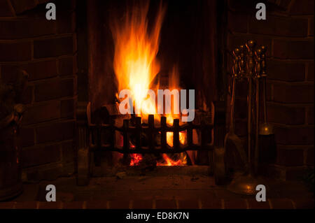 Glow chaleureusement d'une scène d'hiver traditionnels comme le feu ouvert dans une maison rayonne de lumière rougeoyante des braises de charbon de bois et d'enflammer Banque D'Images