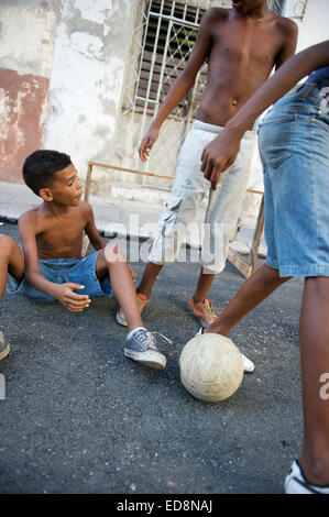 La HAVANE, CUBA - Juin 2011 : les enfants cubains jouent au football ensemble dans une rue calme du centre de La Havane. Banque D'Images