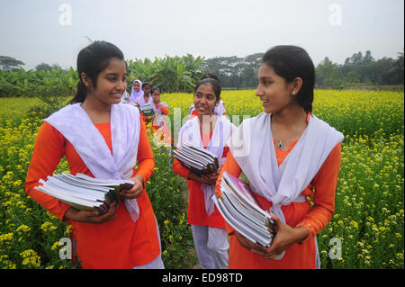 Village du Bangladesh les filles vont à l'école dans le champ avec les manuels scolaires à l'extérieur rassemblement de Dhaka. Banque D'Images